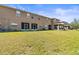 Back view of townhome featuring a screen patio and a green lawn at 10418 Tulip Field Way, Riverview, FL 33578