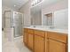 Well-lit bathroom featuring double sinks, a shower, and tile flooring at 10418 Tulip Field Way, Riverview, FL 33578