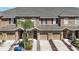 Three townhomes feature an attached garage, a well-manicured lawn, and a cozy front porch at 10418 Tulip Field Way, Riverview, FL 33578
