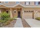 Charming townhome featuring an attached garage, a well-manicured lawn, and a cozy front porch at 10418 Tulip Field Way, Riverview, FL 33578