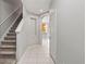 Hallway featuring stairs, neutral paint, and tile floor that leads to a kitchen and dining area at 10418 Tulip Field Way, Riverview, FL 33578