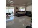Spacious living area with white tile flooring, comfortable sectional sofa, and sliding glass doors to the patio at 1061 6Th Nw St, Largo, FL 33770