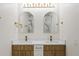 Bathroom with double sinks, quartz countertops, decorative mirrors, and wooden cabinets at 11347 Amboy St, Spring Hill, FL 34609