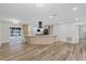 Spacious kitchen featuring quartz countertops, modern appliances, open layout, and wood-look flooring at 11347 Amboy St, Spring Hill, FL 34609