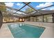 Enclosed pool features a screen enclosure with clear roof panels, providing a bright and airy swimming experience at 11347 Amboy St, Spring Hill, FL 34609