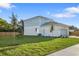 Backyard view of the two-story home with a garage and manicured lawn at 11598 Oak Ln, Largo, FL 33778
