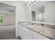 Bathroom featuring granite counters, white cabinets, modern lighting, and an open ensuite at 11598 Oak Ln, Largo, FL 33778