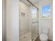 Bathroom features walk-in shower with tile surround, glass door, and a square window at 11598 Oak Ln, Largo, FL 33778