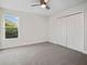 Bright bedroom with neutral carpet, natural light from the window, and a double closet at 11598 Oak Ln, Largo, FL 33778