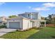 Charming two-story home with a blue and white exterior, manicured lawn, and paved driveway at 11598 Oak Ln, Largo, FL 33778
