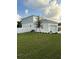 This exterior features white and light blue siding, a well-maintained lawn, and a white fence for added privacy at 11598 Oak Ln, Largo, FL 33778