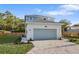 Attractive two-story home featuring a light blue garage door, complemented by a lush green lawn and a partially fenced yard at 11598 Oak Ln, Largo, FL 33778