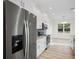 Modern kitchen featuring stainless steel appliances, a blue backsplash, and white cabinets at 11598 Oak Ln, Largo, FL 33778