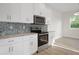 New kitchen with mosaic backsplash, stainless steel appliances and granite countertops at 11598 Oak Ln, Largo, FL 33778