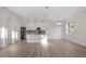 Open-concept area with wood floors, white cabinets, granite countertops, and modern appliances at 11598 Oak Ln, Largo, FL 33778