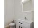 Bright powder room featuring a white vanity, modern fixtures, and a square mirror at 11598 Oak Ln, Largo, FL 33778