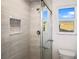 Bathroom features walk-in shower with tile surround, glass door, and a square window at 11598 Oak Ln, Largo, FL 33778
