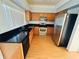 Well-lit kitchen featuring wood cabinets, black countertops, and stainless-steel appliances at 12814 Longcrest Dr, Riverview, FL 33579