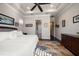 Bright bedroom boasts a ceiling fan, tray ceiling, and hardwood floors at 13917 Kingfisher Glen Dr, Lithia, FL 33547