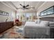 Inviting bedroom featuring plantation shutters, tray ceiling, ceiling fan, and hardwood floors at 13917 Kingfisher Glen Dr, Lithia, FL 33547