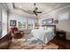 Inviting bedroom featuring plantation shutters, tray ceiling, ceiling fan, and hardwood floors at 13917 Kingfisher Glen Dr, Lithia, FL 33547