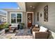 Cozy covered patio with comfortable wicker furniture, a glass table, and decorative touches for outdoor relaxation at 13917 Kingfisher Glen Dr, Lithia, FL 33547
