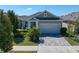 Charming single-story home with a two-car garage, well-manicured landscaping, and a brick-paved driveway at 13917 Kingfisher Glen Dr, Lithia, FL 33547
