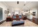 Inviting living room with a comfortable leather sofa and a view of the modern kitchen at 13917 Kingfisher Glen Dr, Lithia, FL 33547