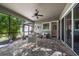 Relaxing screened-in patio boasts brick floors, fan, and peaceful backyard views at 13917 Kingfisher Glen Dr, Lithia, FL 33547