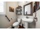Charming powder room features pedestal sink, decorative mirror, and modern fixtures at 13917 Kingfisher Glen Dr, Lithia, FL 33547