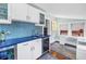 Wet bar featuring blue countertops, wine cooler, glass-front cabinets, tile backsplash, and a desk at 145 19Th Se Ave, St Petersburg, FL 33705