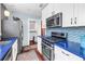 Bright kitchen with white cabinets, blue countertop, mosaic backsplash, and stainless steel appliances at 145 19Th Se Ave, St Petersburg, FL 33705