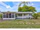 Charming backyard featuring a covered patio, serene green lawn, and stylish shutters, perfect for relaxing or entertaining at 1496 Queen Anne Dr, Palm Harbor, FL 34684