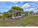 Charming backyard showcasing a screened-in porch, lush greenery, and a well-maintained lawn perfect for outdoor enjoyment at 1496 Queen Anne Dr, Palm Harbor, FL 34684