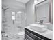 This bathroom features a glass shower and a modern sink with a large mirror at 1496 Queen Anne Dr, Palm Harbor, FL 34684