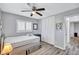 Cozy bedroom with a ceiling fan, light gray walls, and wood-look floors at 1496 Queen Anne Dr, Palm Harbor, FL 34684