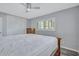 Bedroom with wood floors, white trim, ceiling fan, neutral paint, and large wardrobe at 1496 Queen Anne Dr, Palm Harbor, FL 34684