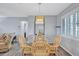 Dining room with glass table, seating for four, hard wood floors, modern light fixture, and neutral paint at 1496 Queen Anne Dr, Palm Harbor, FL 34684