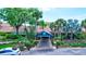 Welcoming main entrance features lush landscaping, and convenient covered drop-off, offering a grand arrival at 1496 Queen Anne Dr, Palm Harbor, FL 34684