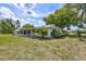Charming home with screened lanai and lush landscaping creates a peaceful outdoor living space at 1496 Queen Anne Dr, Palm Harbor, FL 34684