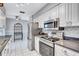 Modern kitchen with stainless steel appliances, white cabinets, and ample counter space at 1496 Queen Anne Dr, Palm Harbor, FL 34684