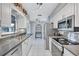 Kitchen with stainless steel appliances, white cabinets, and a view to the dining area at 1496 Queen Anne Dr, Palm Harbor, FL 34684
