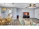 Bright living room with hardwood floors, ceiling fan, dining table, white trim, and a mounted television at 1496 Queen Anne Dr, Palm Harbor, FL 34684