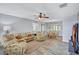 Comfortable living room with ceiling fan, light grey paint, wood-look flooring, and furniture with palm leaf accents at 1496 Queen Anne Dr, Palm Harbor, FL 34684