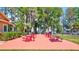 Outdoor patio area with vibrant red picnic tables and lush green landscaping, perfect for community gatherings at 1496 Queen Anne Dr, Palm Harbor, FL 34684