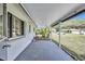 Covered patio with concrete floor, white paint, and views of the yard and neighborhood at 1496 Queen Anne Dr, Palm Harbor, FL 34684