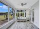 Bright sunroom with floor to ceiling windows and comfortable seating at 1496 Queen Anne Dr, Palm Harbor, FL 34684