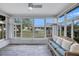 Bright sunroom with floor to ceiling windows and comfortable seating at 1496 Queen Anne Dr, Palm Harbor, FL 34684