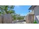 Private backyard area showcasing a covered parking spot, mature trees, and a wooden fence at 1726 25Th S Ave, St Petersburg, FL 33712