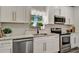 Stylish kitchen featuring white cabinets, granite countertops, and stainless steel dishwasher at 1726 25Th S Ave, St Petersburg, FL 33712